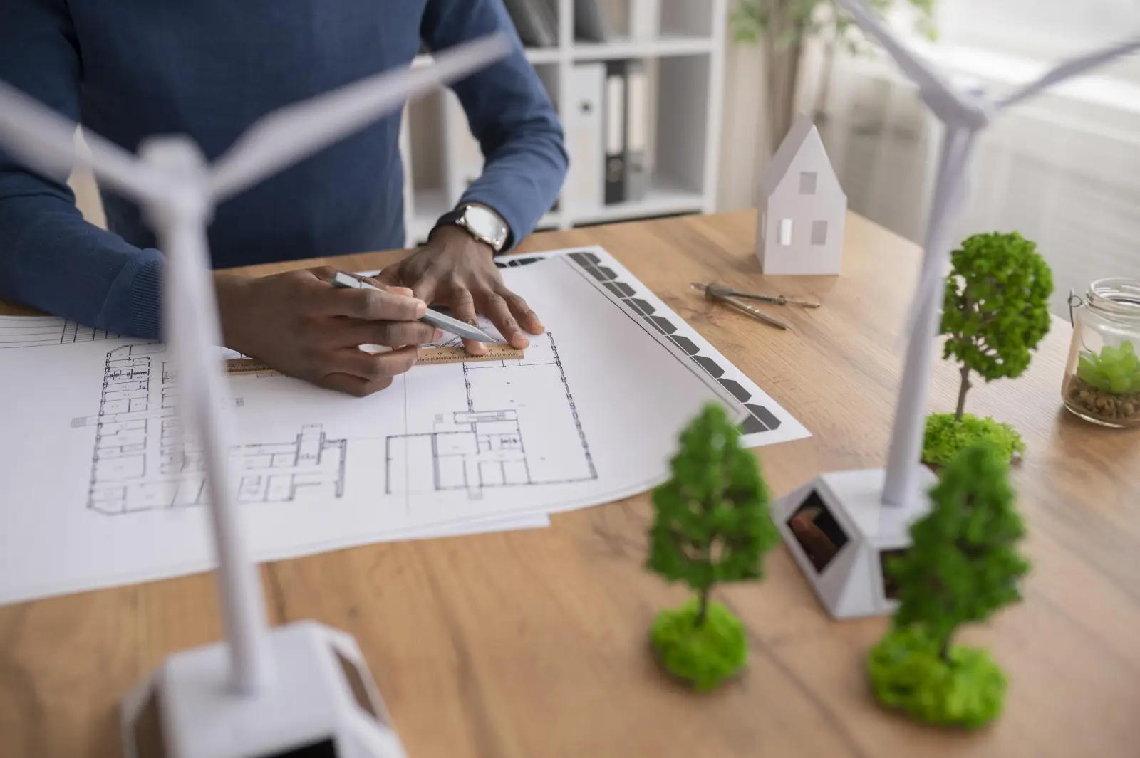 Plans, maquette et étiquettes énergie posés sur une table de travail